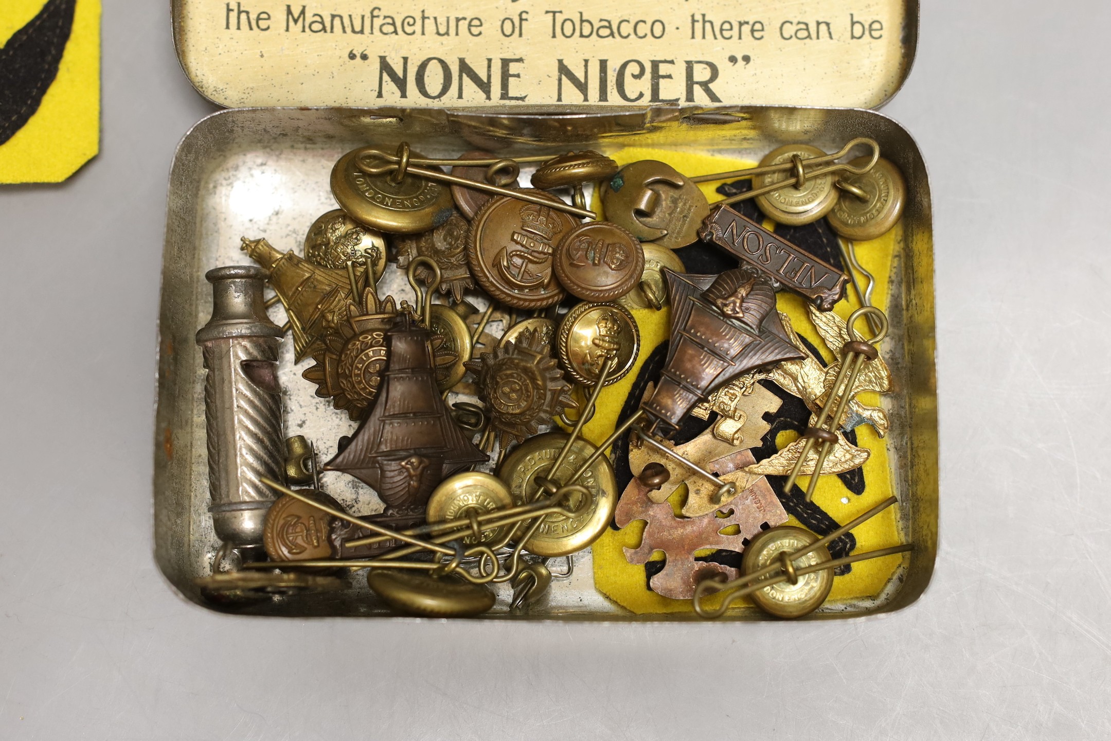 A collection of mixed cap badges and whistle